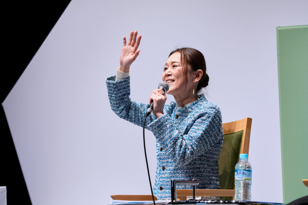日本製紙クレシア株式会社 常務取締役 マーケティング総合企画本部 本部長　髙津尚子氏がステージ上でクレシア流「選ばれる仕組み」について話す様子