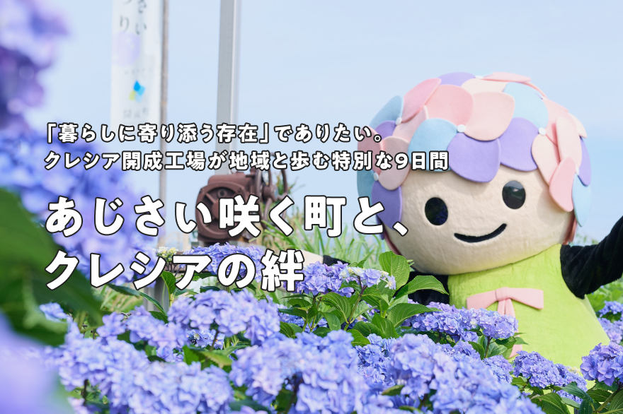 あじさいちゃんがあじさいの咲く農道で手を振っている様子