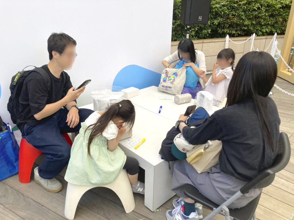 子どもたちがウェットティッシュの容器にお絵描きをしている様子