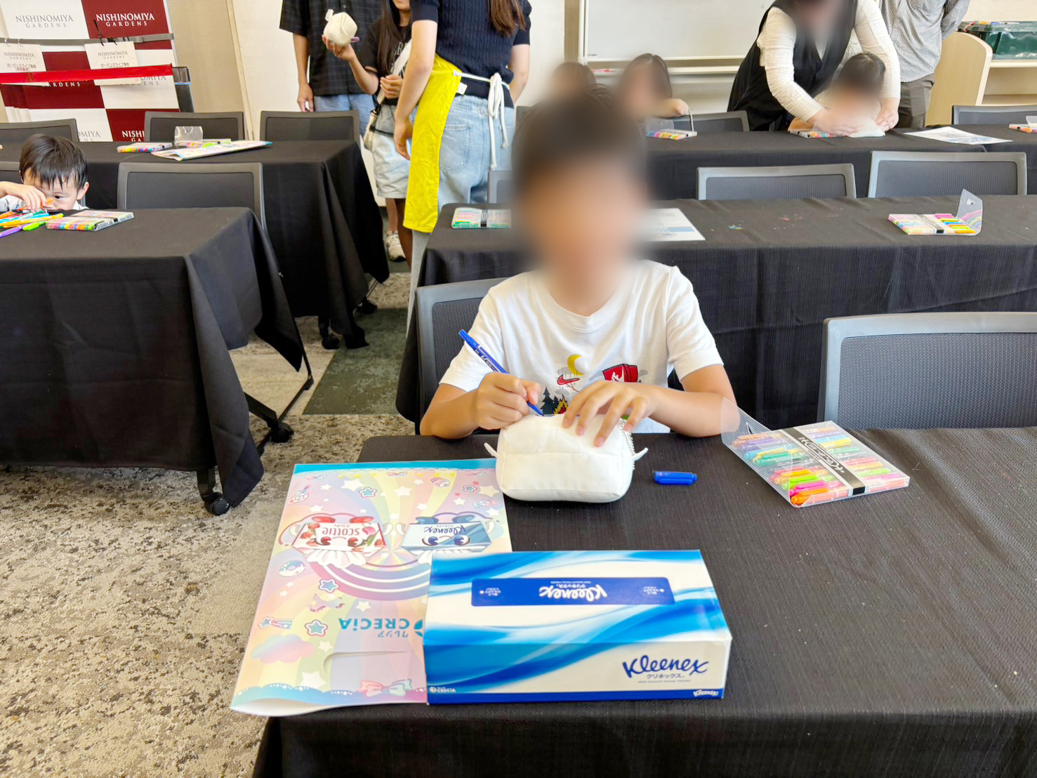 「ごっこランドEXPO」に参加し、クレシアのブースでぬいぐるみの色塗り体験をする子どもの様子①