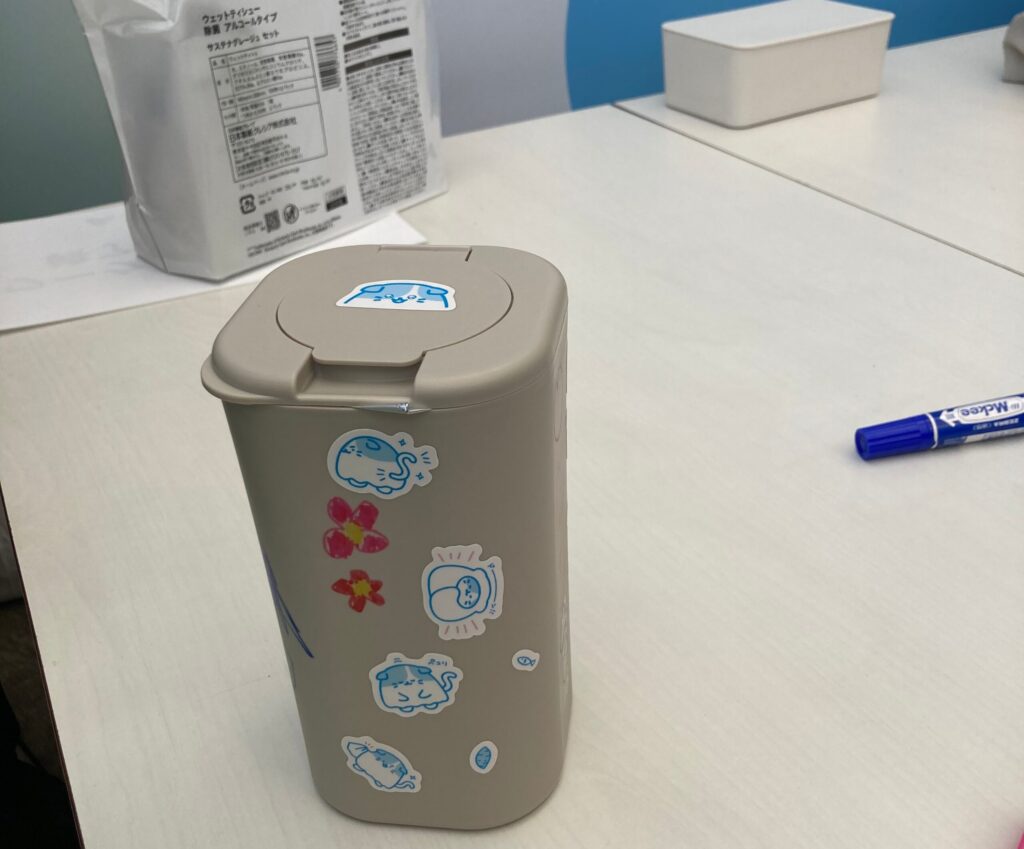 子どもたちがシールを貼ったり、ペンでお絵描きをしたウェットティッシュの容器の写真